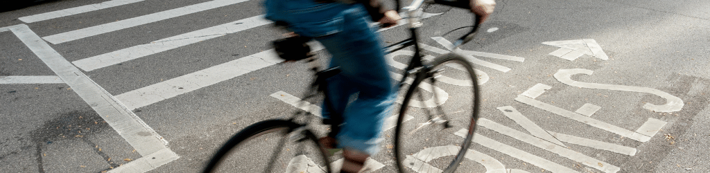 unrecognizeable person on a bike crossing a pedestrian crossing