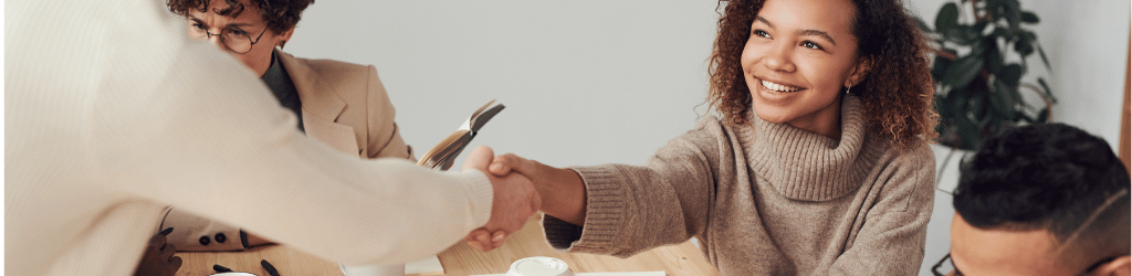 Two smiling people shaking hands,