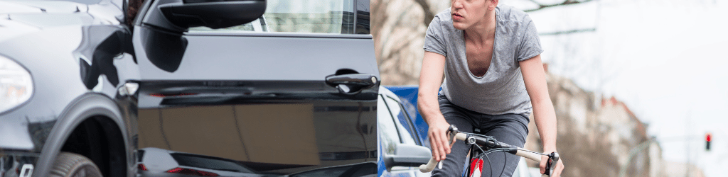 Driver opening car door as cyclist approaches.