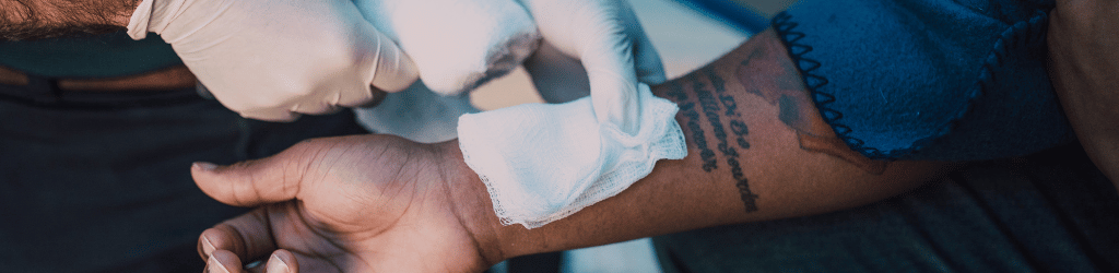 Person having a white bandage applied to hand