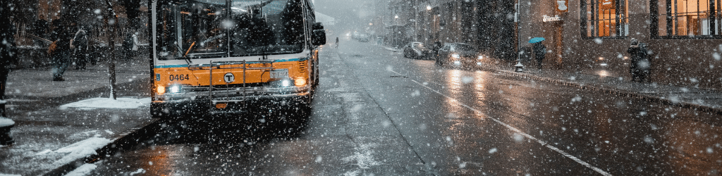 Street view of on coming bus in the snow.