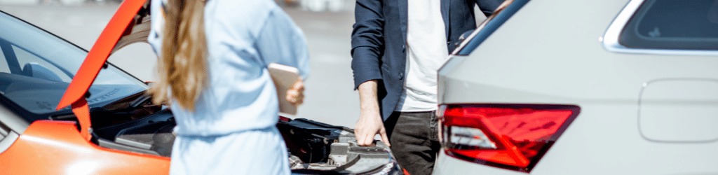 Two drivers inspecting car damage after a trafficaccident