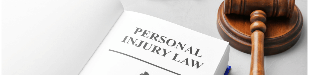 A book on a desk titled 'Personal Injury Law', with a gavel next to it.